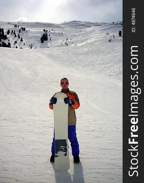 Snowboarder standing on a slope with his desk