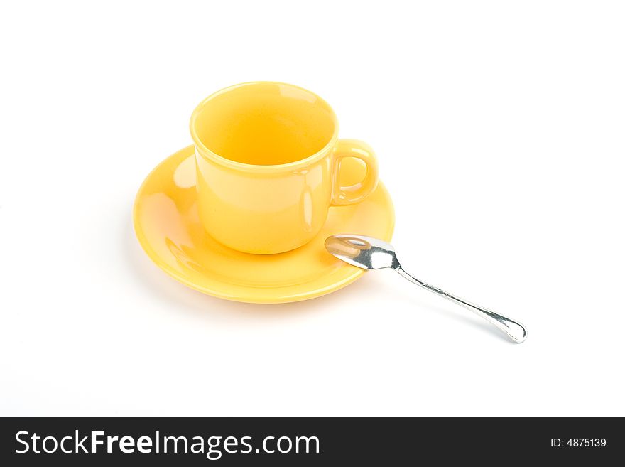 Yellow cup with spoon on a white