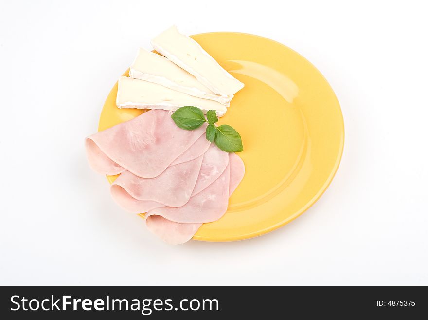 Ham and cheese with basil on a plate. Ham and cheese with basil on a plate