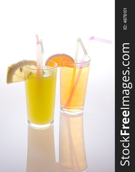 Fruit juice in glasses with straws