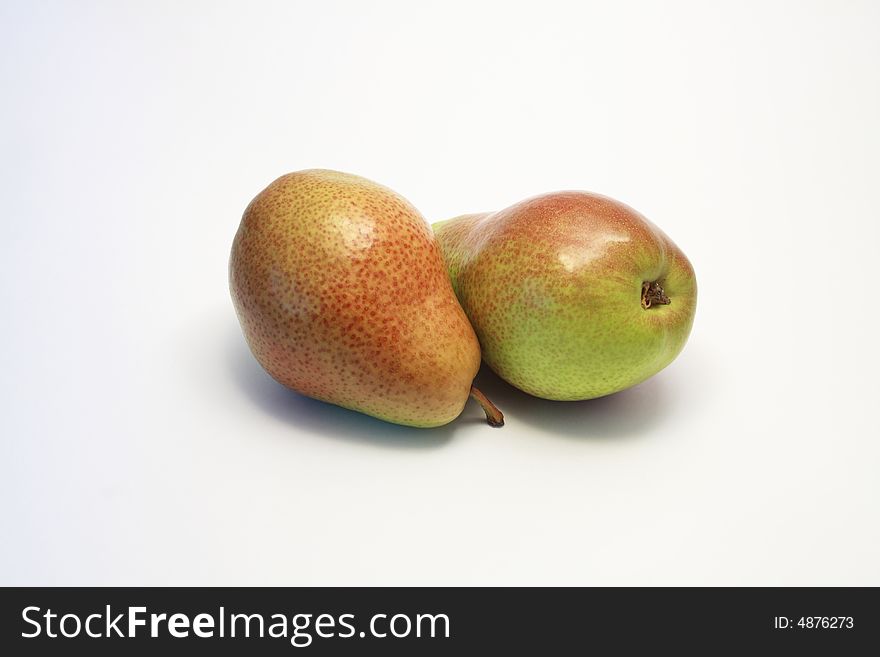 Two ripe red and green pears lying on white background. Two ripe red and green pears lying on white background