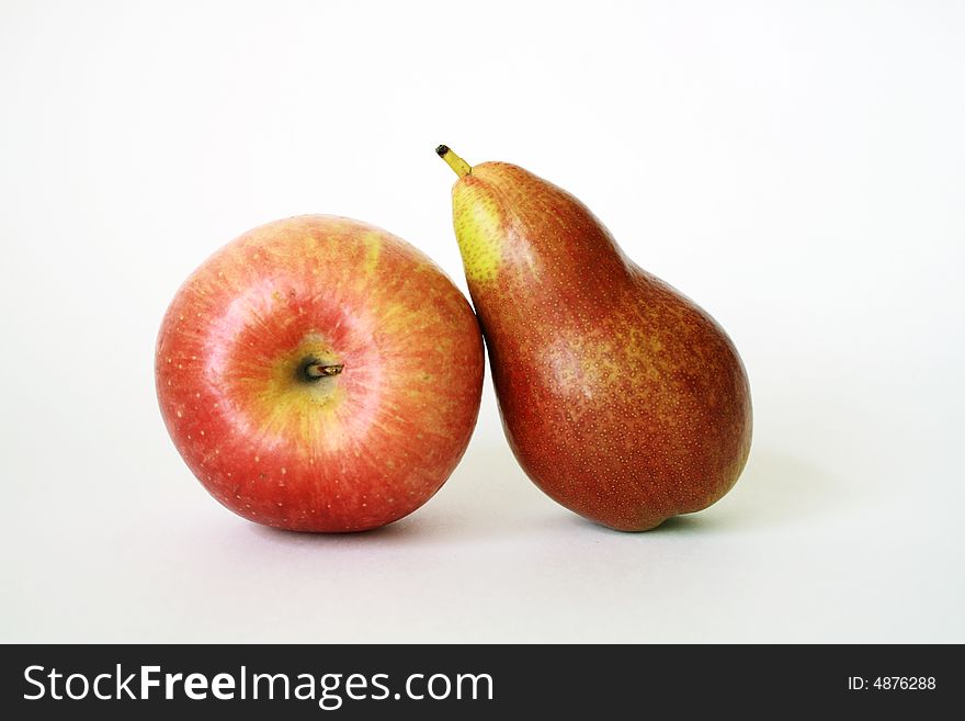 Ripe red apple and green pear lying on white background. Ripe red apple and green pear lying on white background