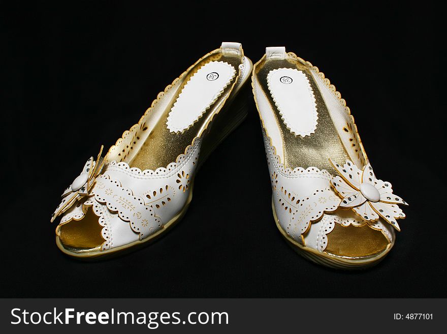 A pair of lady shoe with black background.