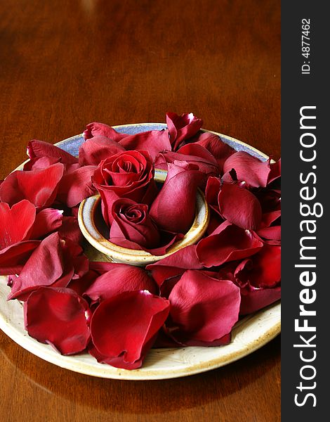 Rose buds and petals on ceramic platter. Rose buds and petals on ceramic platter