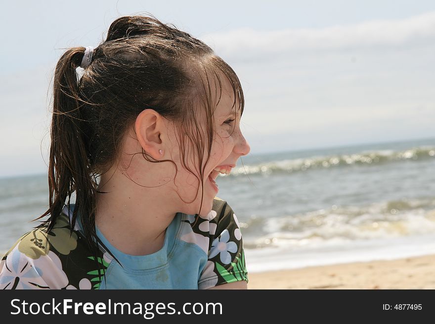 A young girl playing and laughing on the beach. A young girl playing and laughing on the beach.