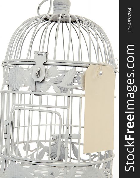 White birdcage with cream sale tag tied to the side. White birdcage with cream sale tag tied to the side.