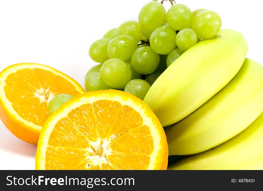 Grapes, bananas and two halves of orange close-up