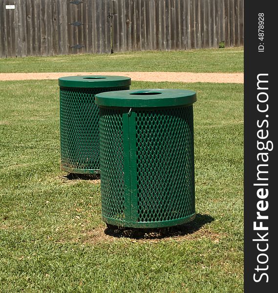Dark green trash bins outdoors on grass. Dark green trash bins outdoors on grass.