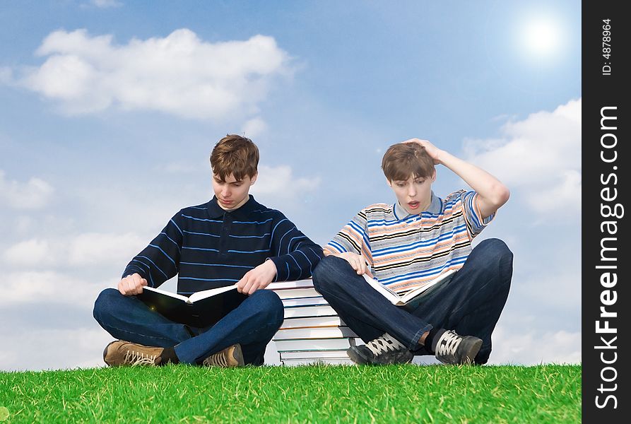 The two students with the book on a background of the blue sky