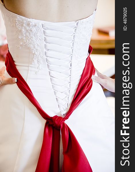 Wedding dress with red sash.
