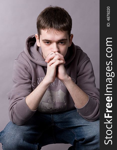 The young guy in studio on a grey background