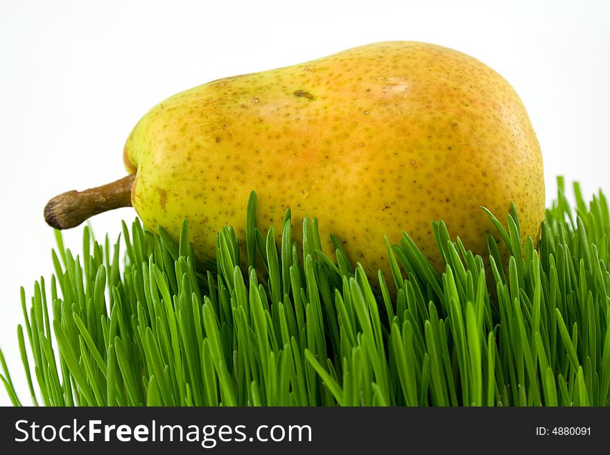 Yellow pear on grass isolated on white