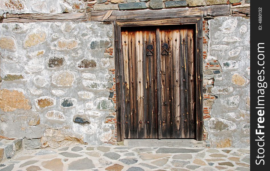 Old wooden church door on a stone-wall