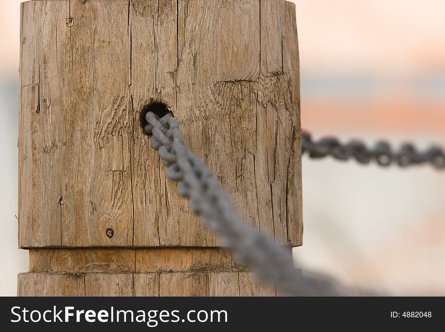 Chain link through a hole in a post. Narrow depth of focus. Chain link through a hole in a post. Narrow depth of focus.