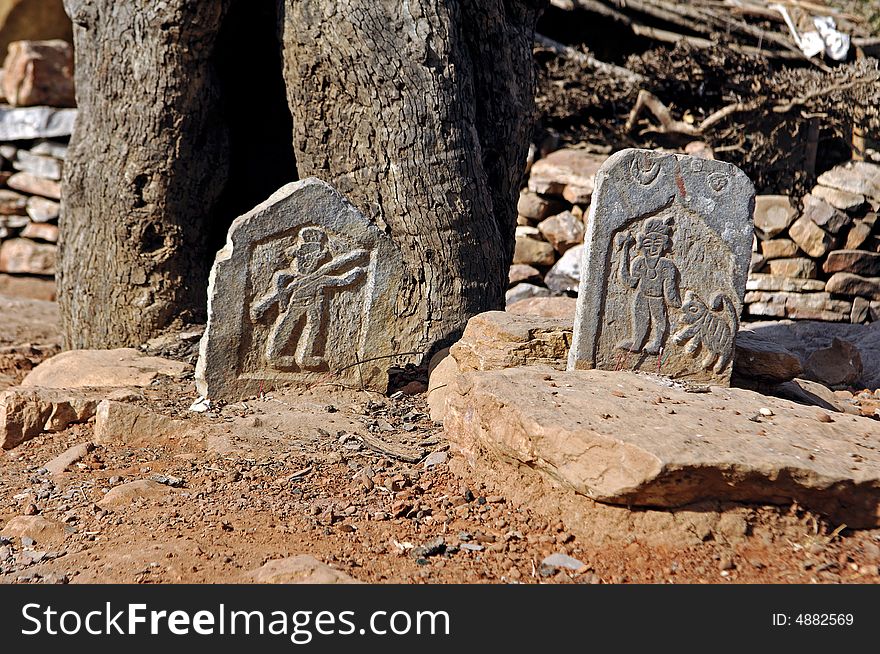 India, Chittorgarh: Tombs near Chittorgarh; red sand and small carved stones with figures
