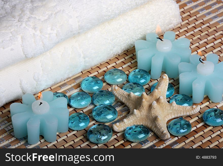 Bath towels, candles, starfish and glass pebbles. Bath towels, candles, starfish and glass pebbles