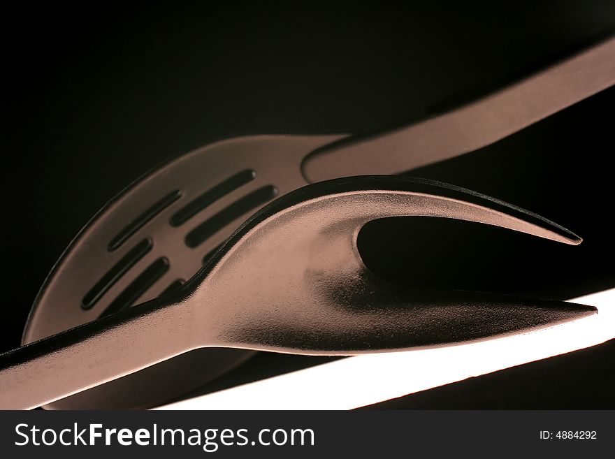 Abstract design of plastic serving pieces on black background.