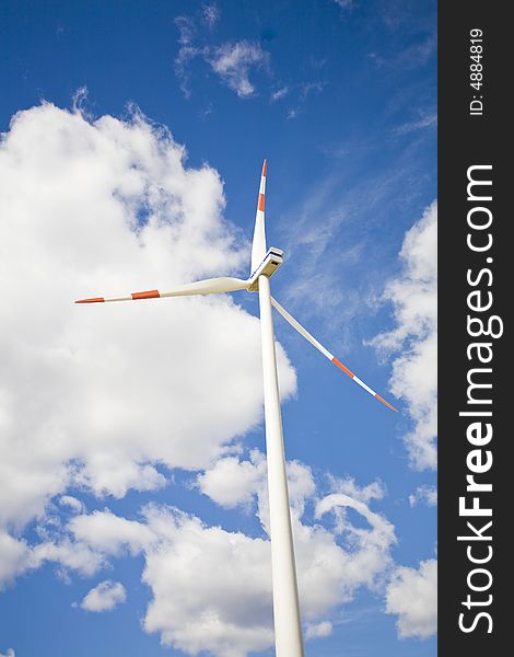 Modern wind energy plant on green fields with a clouds in the background. Modern wind energy plant on green fields with a clouds in the background