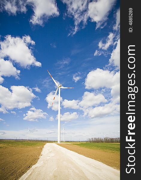 Modern wind energy plant on green fields with a clouds in the background. Modern wind energy plant on green fields with a clouds in the background