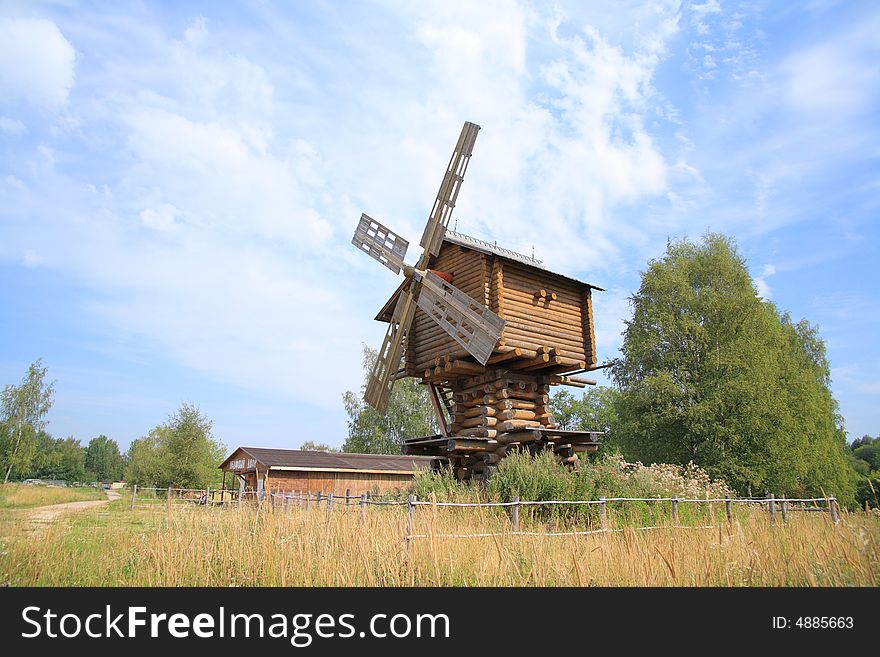 Wooden windmill on a background of the blue sky