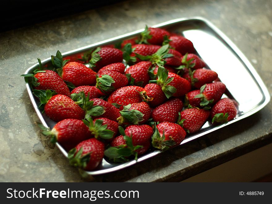 A lot of fresh strawberries on silver plate