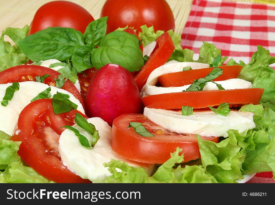 Caprese - Italian salad with tomatos, radish and mozarella cheese. Caprese - Italian salad with tomatos, radish and mozarella cheese