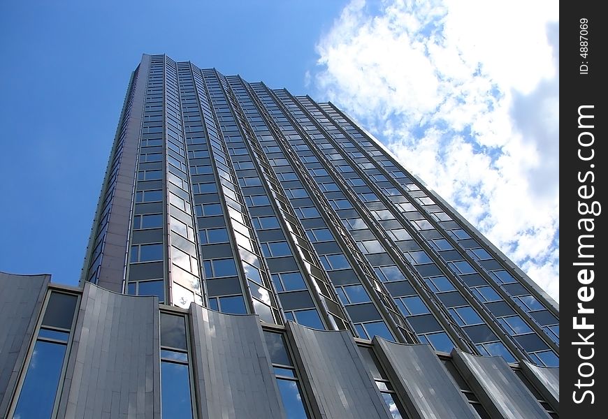 Skyscraper on a background of the blue sky and white clouds. Skyscraper on a background of the blue sky and white clouds