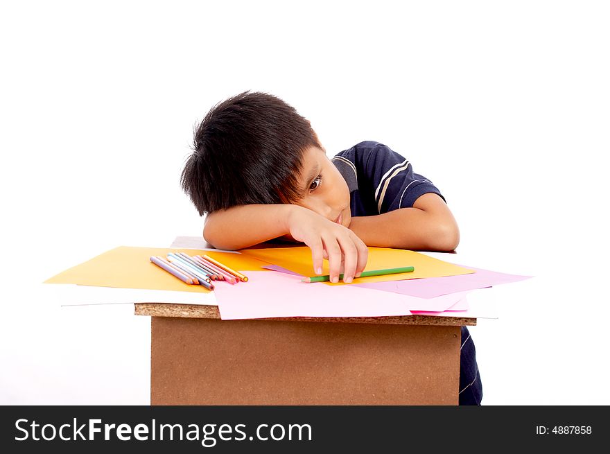 Young man lying on desk holding colored pencil