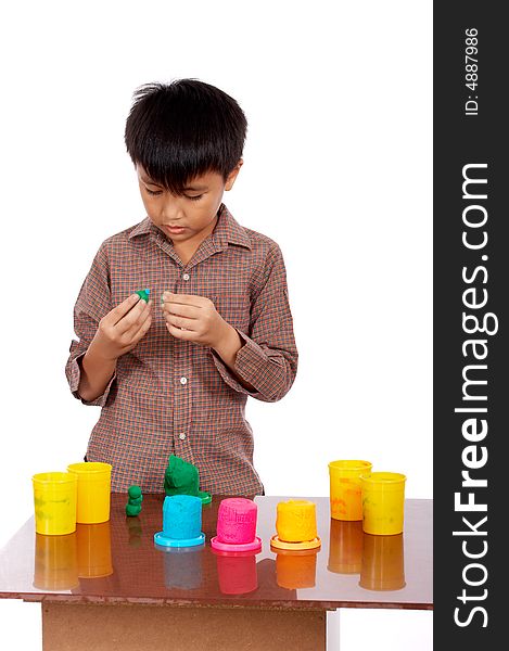 Young man seriously playing colorful clay dough