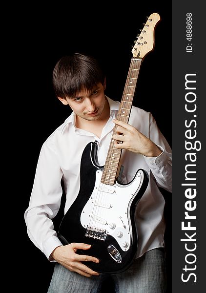 Young man with guitar isolated on black