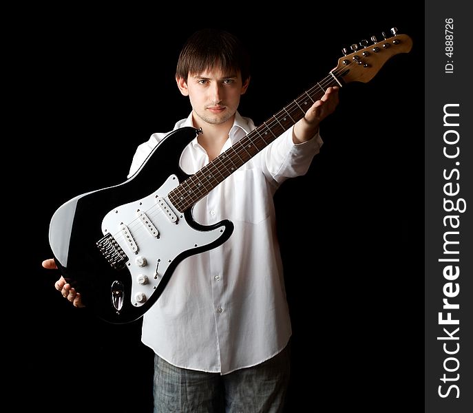 Young man with guitar isolated on black