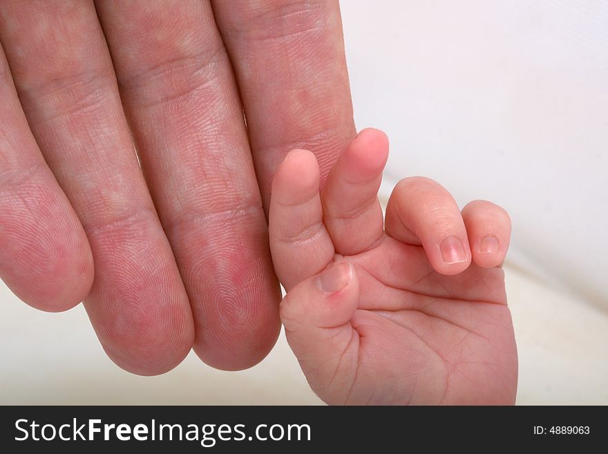 Parent hand over newborn child hand. Parent hand over newborn child hand