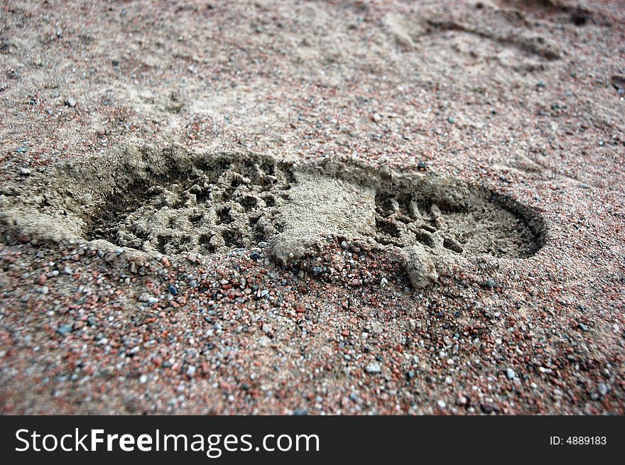 Foot print of boots in mud and sand