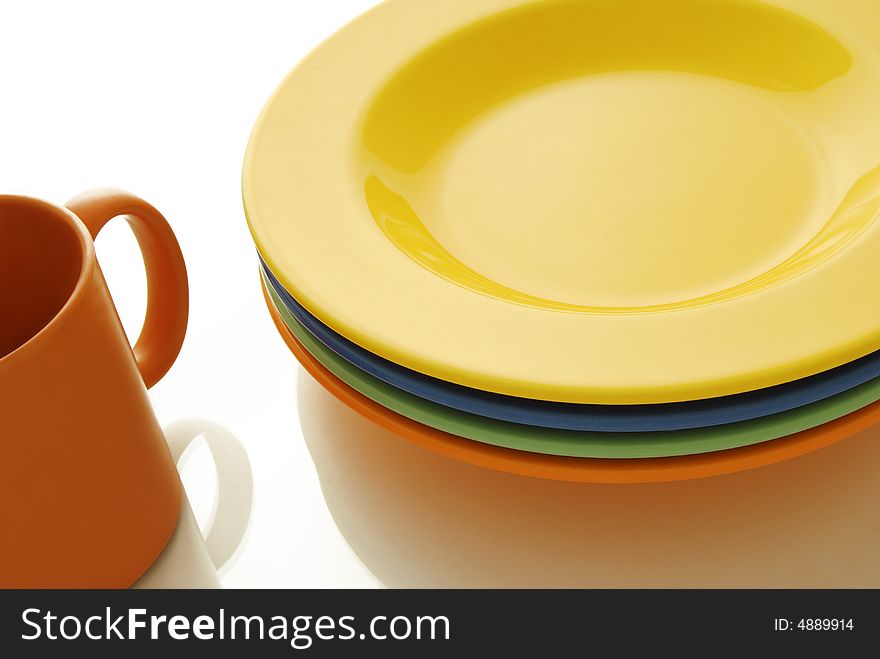 Closeup of a place setting with color ceramics plates and mug. Closeup of a place setting with color ceramics plates and mug