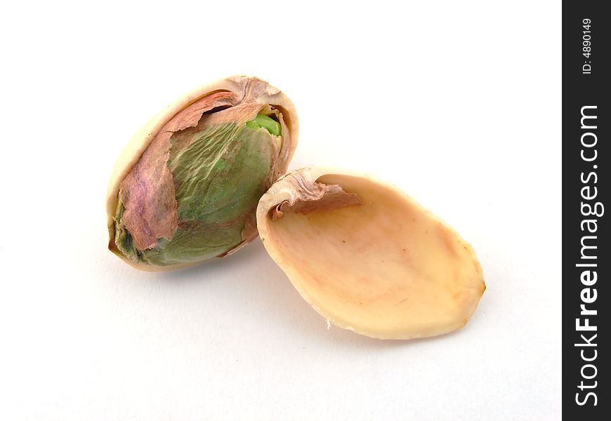 Pistachio nut with half shell removed showing green kernel