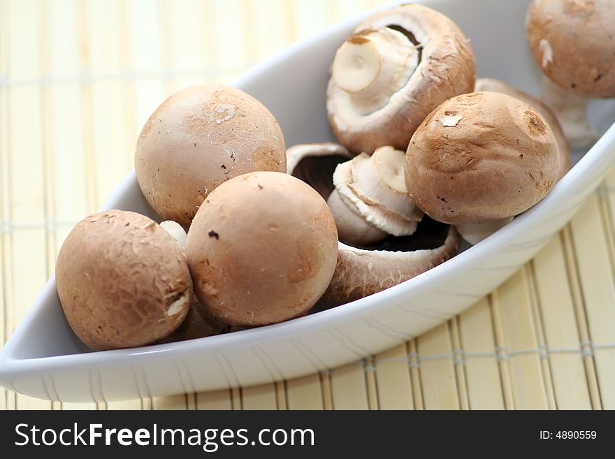Some brown mushrooms in a decorative bowl