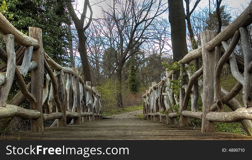 A small bridge made of wood with interesting handrail. A small bridge made of wood with interesting handrail