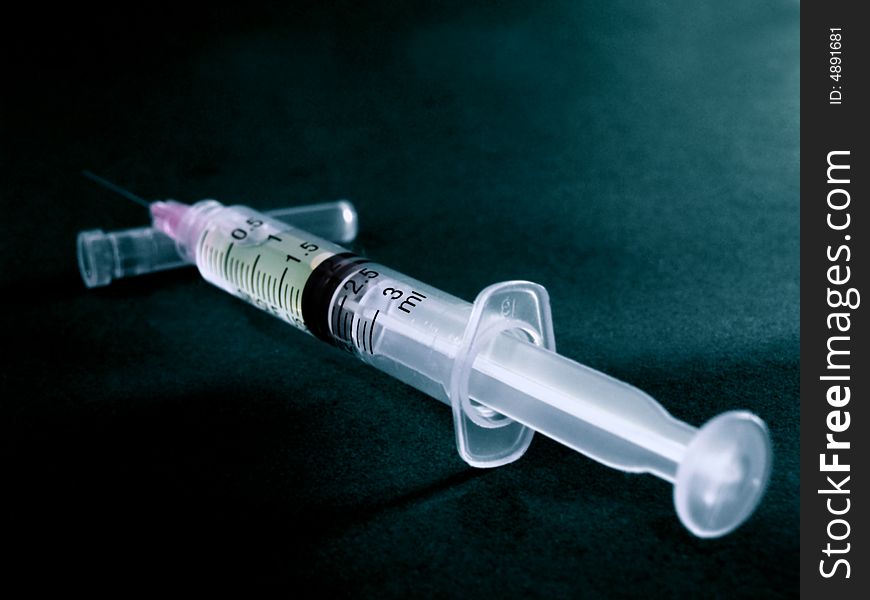 A hypodermic Needle & Syringe on a black background.