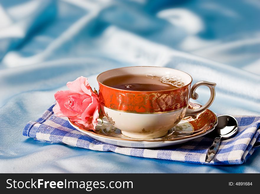 Cup of tea with flower over azure