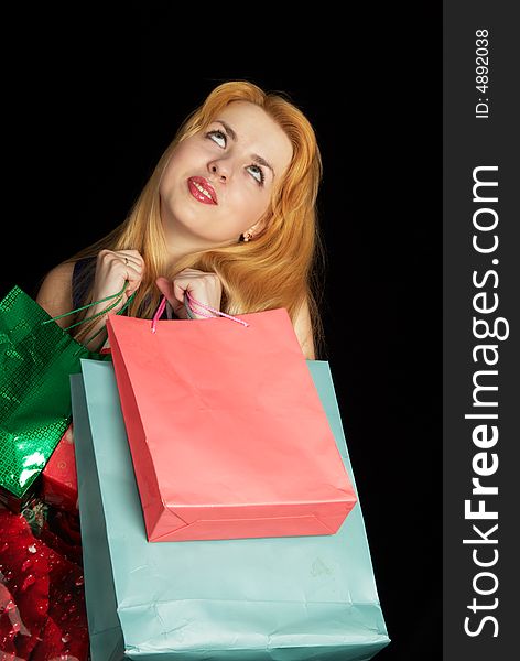 Blond girl with shopping bags over black background. Blond girl with shopping bags over black background
