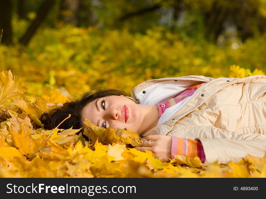 Young pretty woman on the autumn leaf