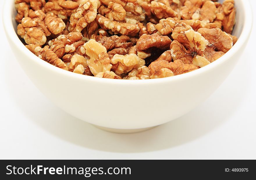 Half a bowl of walnuts on a white background