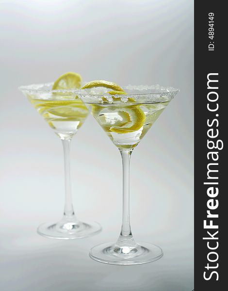 Martini with sugar crust, lemon and peels on white