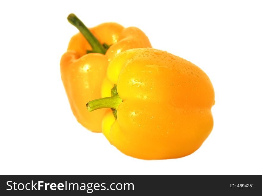 Two yellow peppers wit drops of water isolated