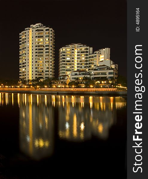 Modern Towers are reflected in a still river near the sea. Modern Towers are reflected in a still river near the sea.