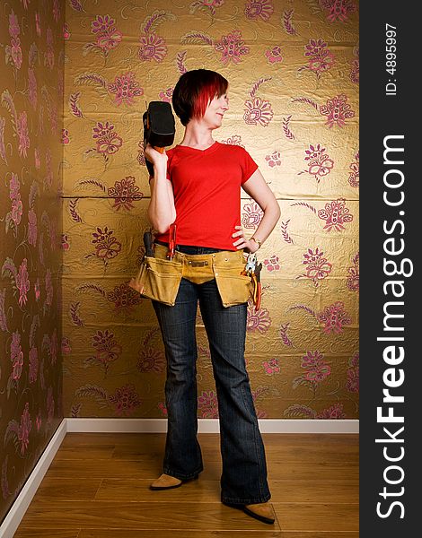 Young adult holding a drill and wearing a toolbelt. Young adult holding a drill and wearing a toolbelt