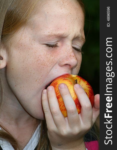 A white caucasian girl child enjoying an apple. A white caucasian girl child enjoying an apple