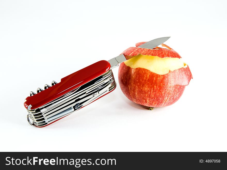 Pocket knife and partially peeled apple, on white background