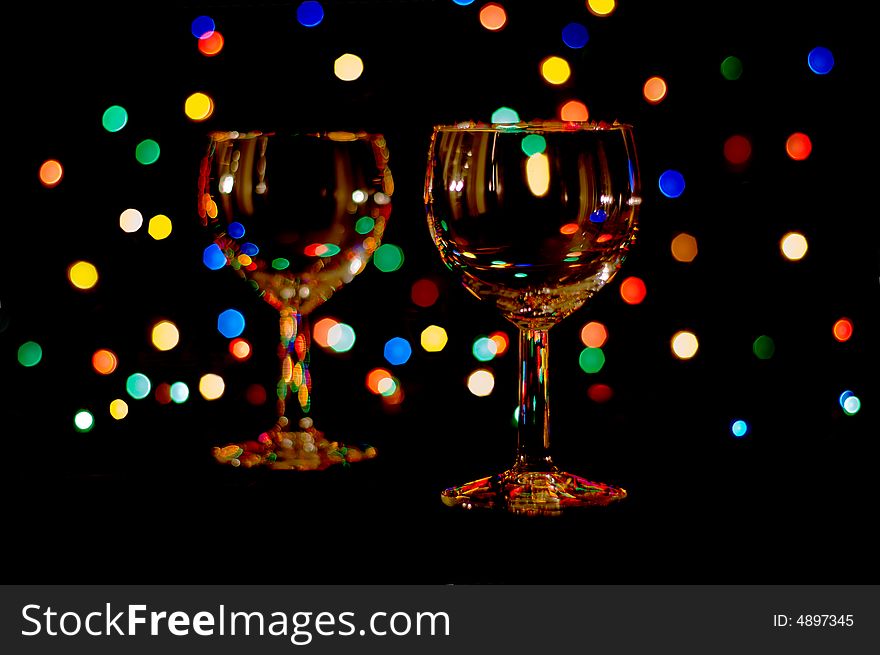 Two wine glasses with colored lens flares. Two wine glasses with colored lens flares