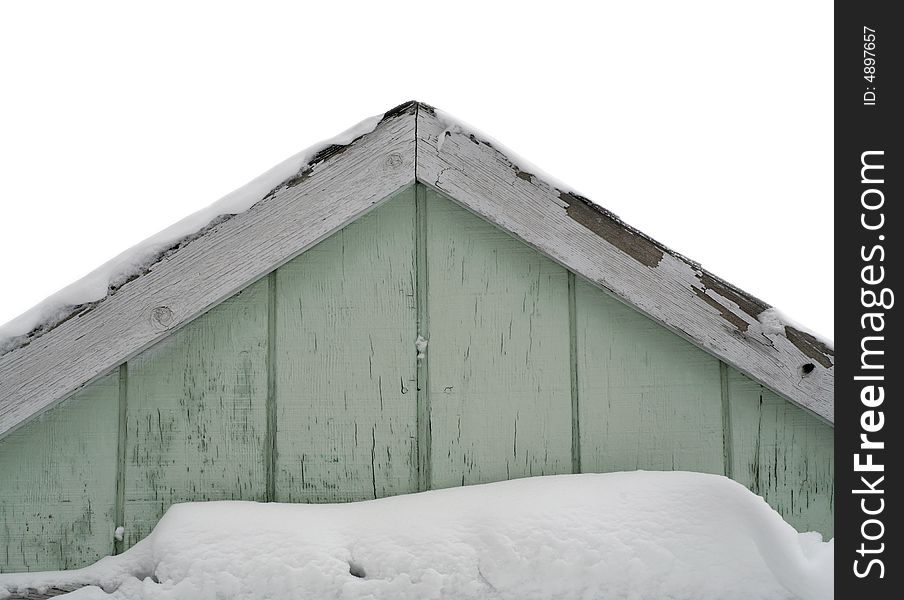 Snow drifted against gable of weathered old shed. Snow drifted against gable of weathered old shed